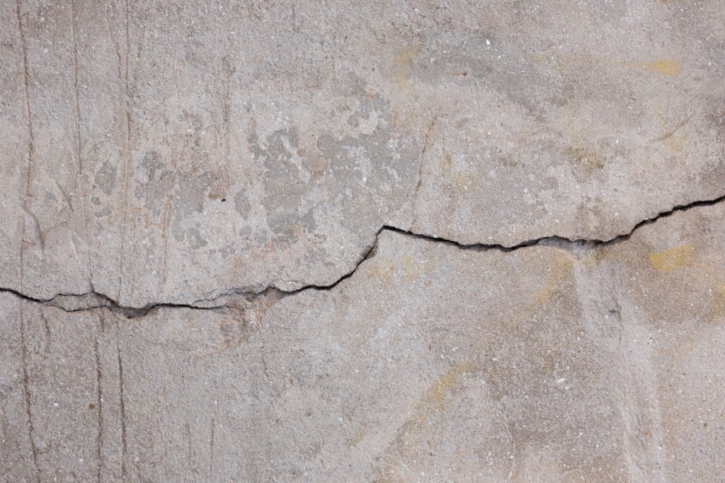 Close view of cracked concrete on slab foundation of a home.